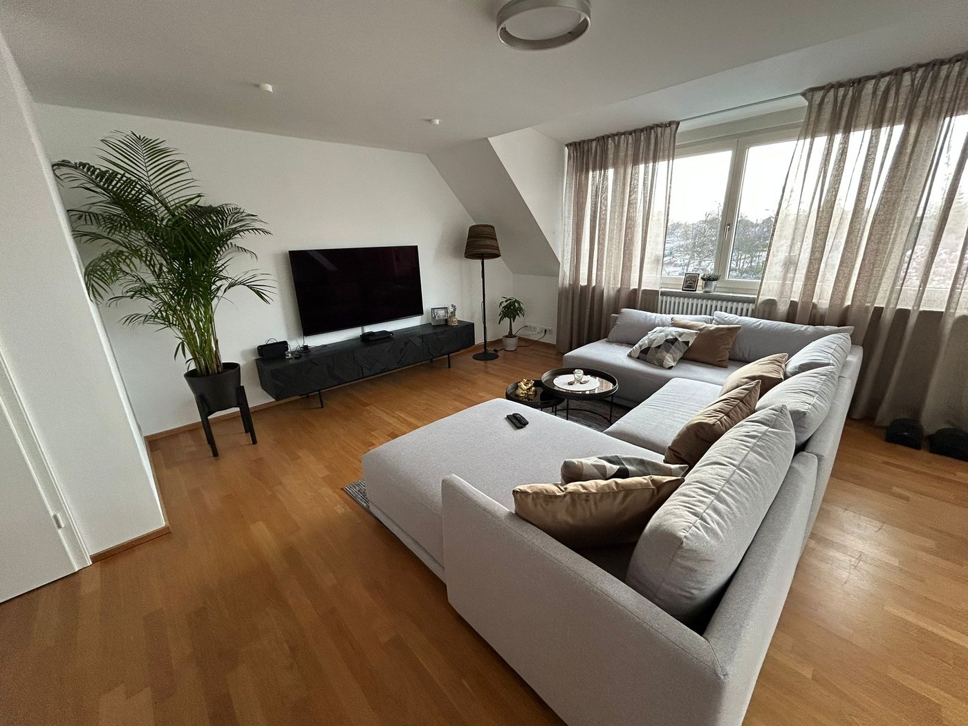 Wohnbereich mit heller Sofalandschaft und Dachschräge